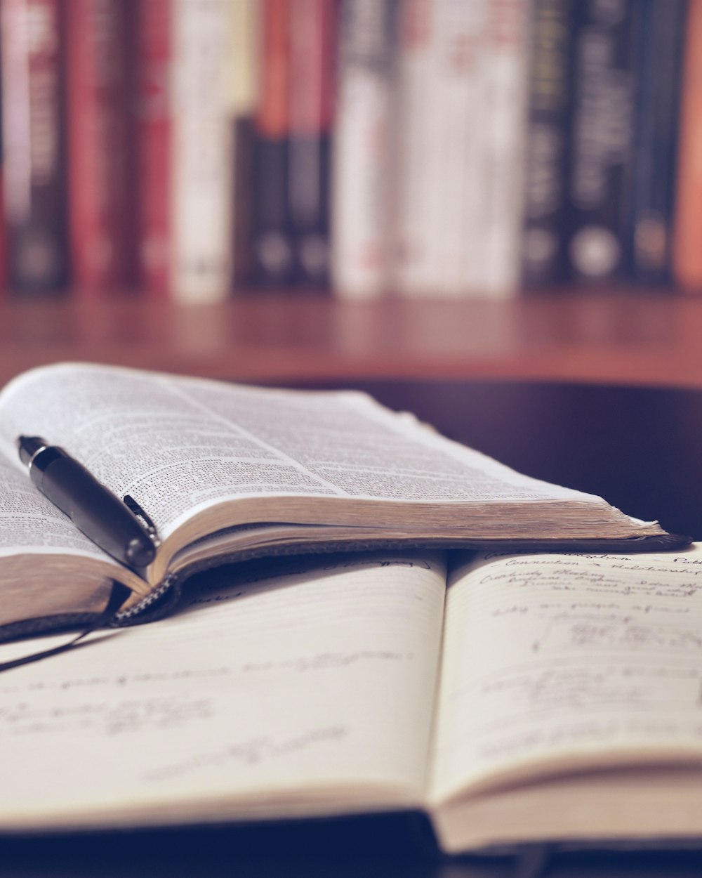 Escritorio con cuaderno, apuntes y una lapicera durante una corrección